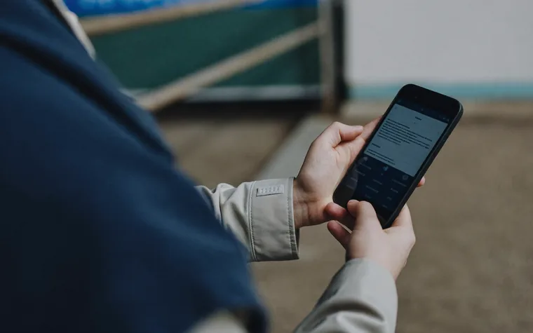 A worker checking their training record on a phone while out on site