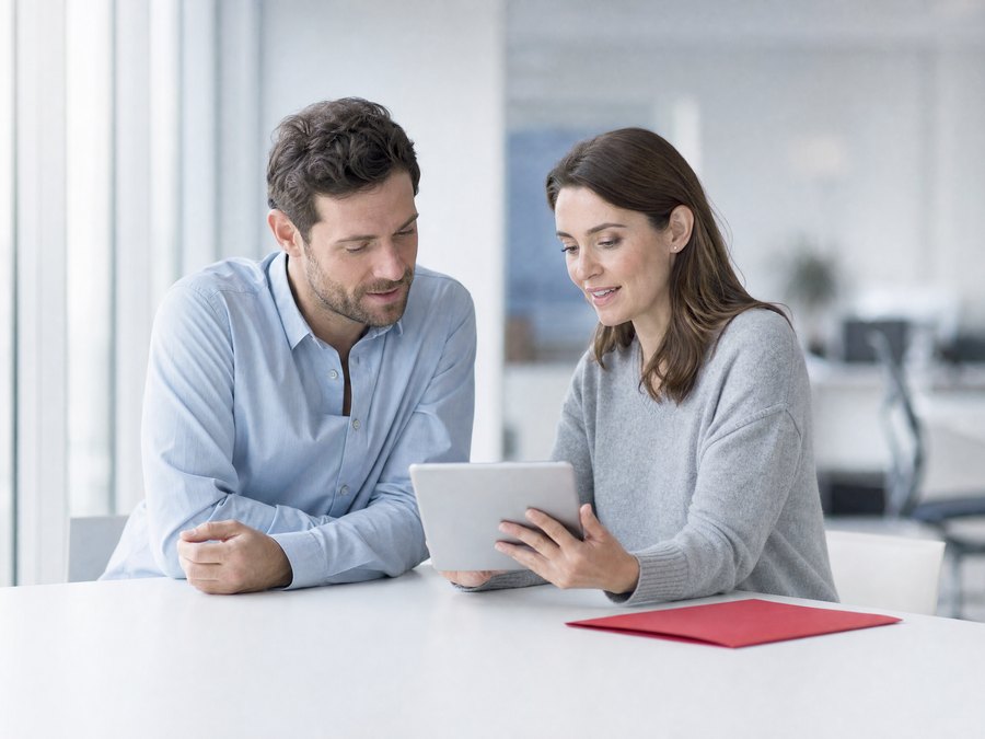 Two colleagues looking together at a tablet, choosing a course